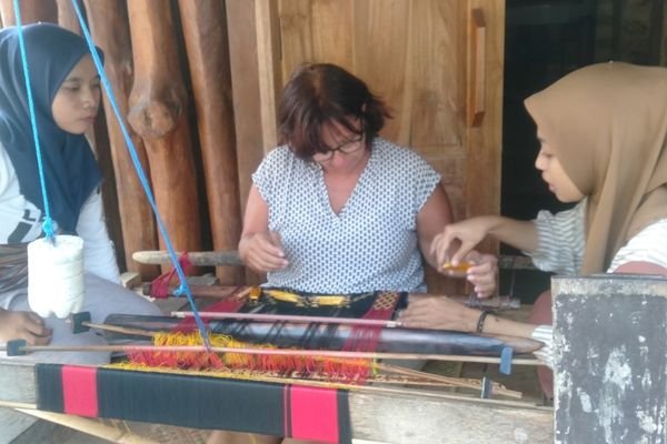 Tourist trying traditional Sasak clothes in Sukarara